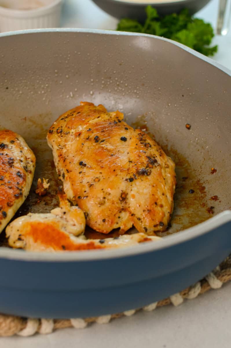 Cooking chicken breast in a pan.