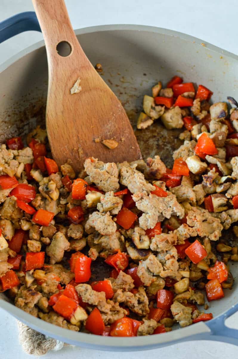 Cooking sausage and veggies in a pan.