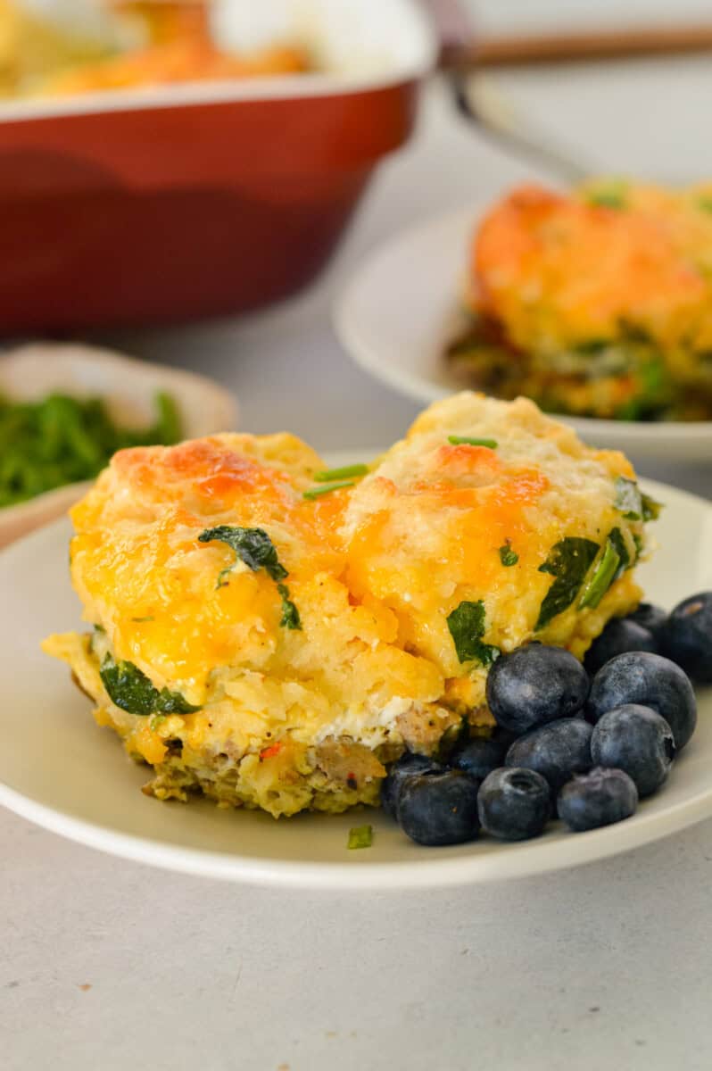 A plate with a slice of biscuit breakfast casserole and blueberries.