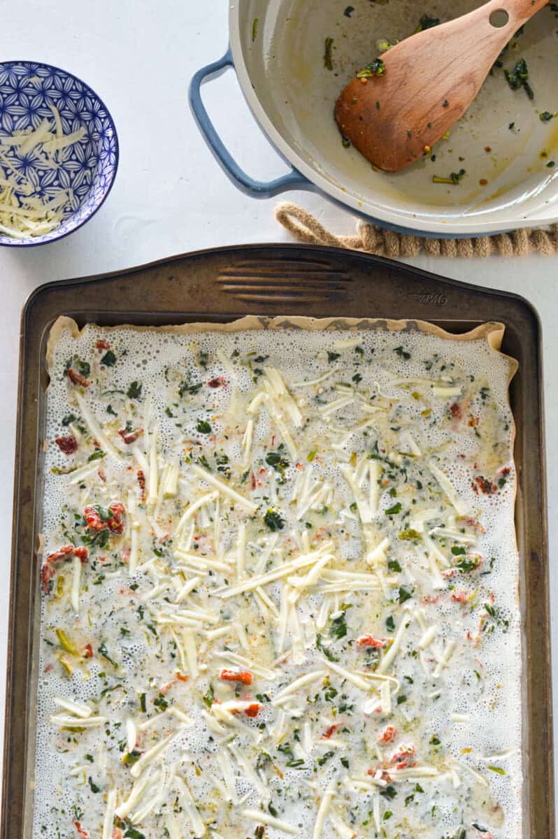 Adding cheese to egg whites in tray pan.