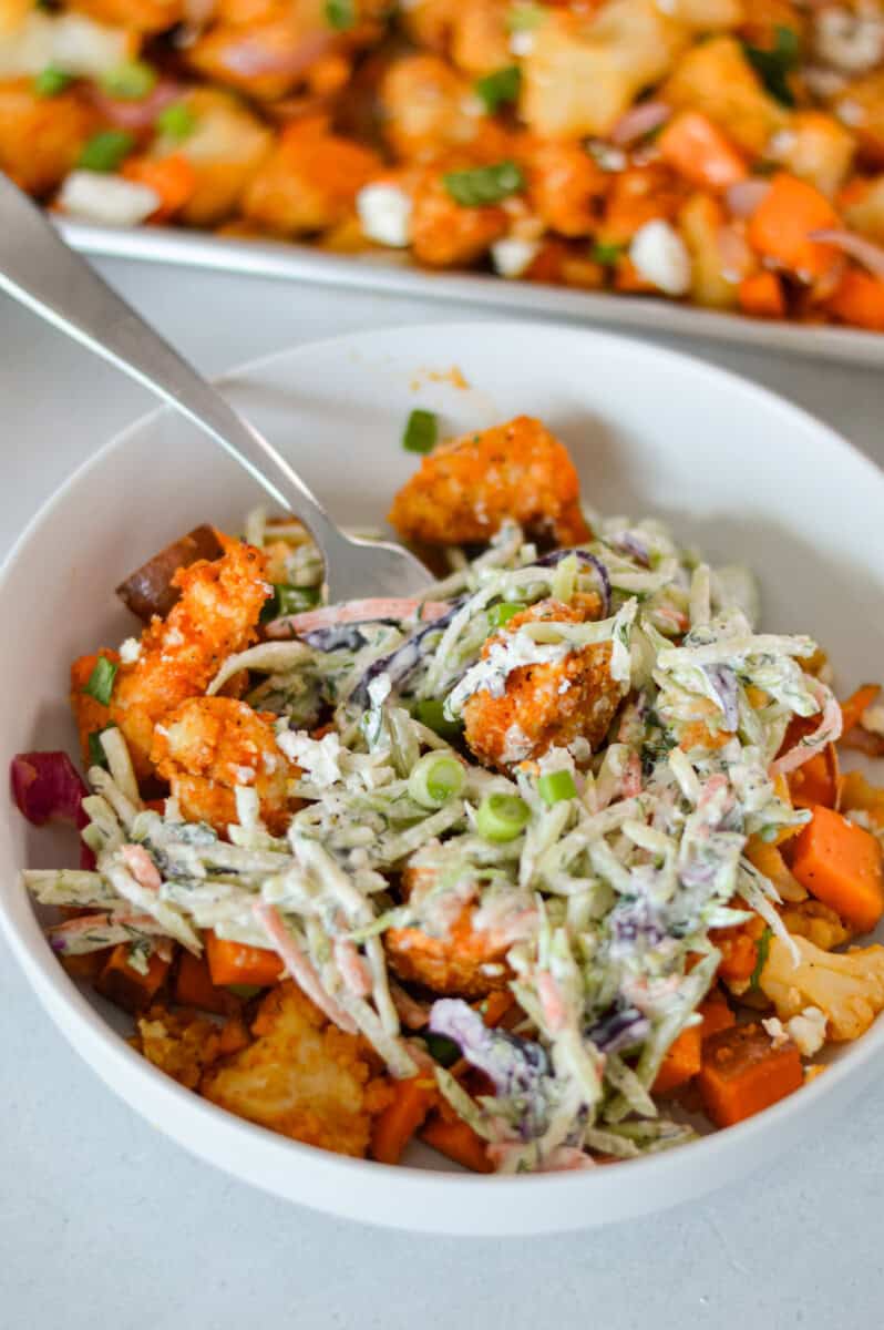 Buffalo chicken and sweet potato bowl served with coleslaw.