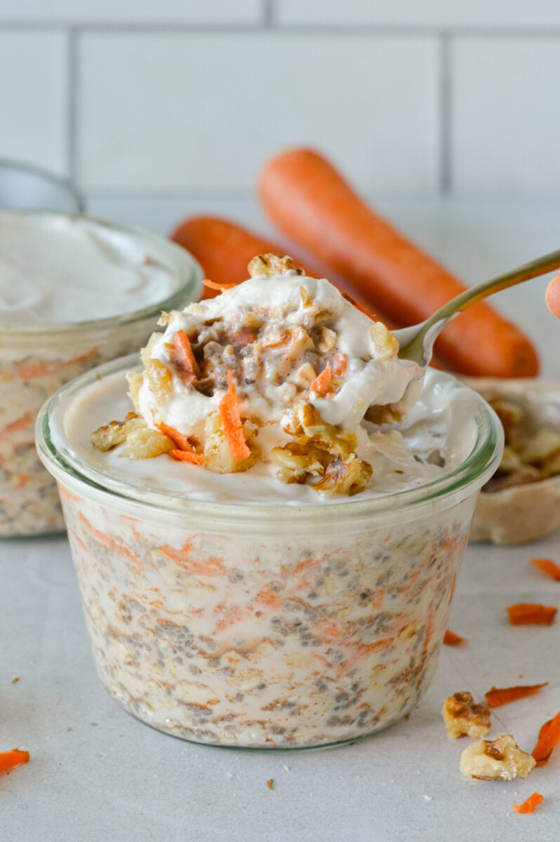 Jar of carrot cake overnight oats with a spoon.
