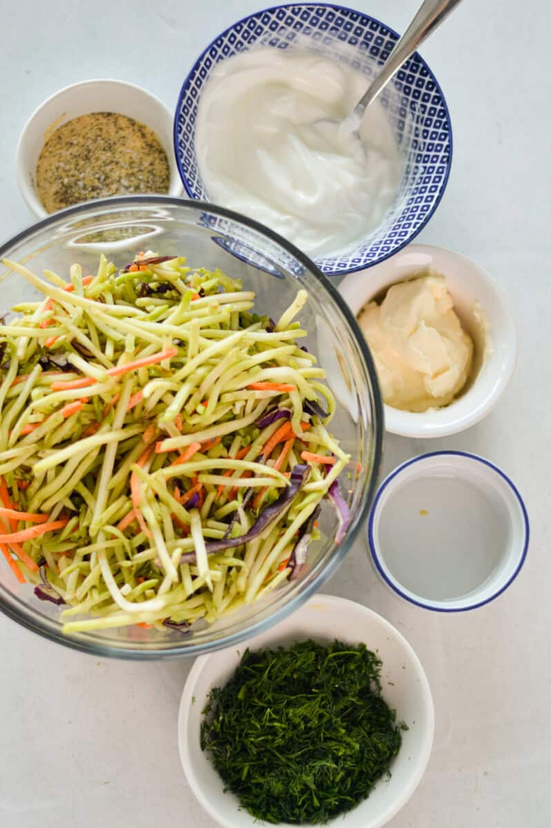 Ingredients including coleslaw mix, greek yogurt, mayonnaise, seasoning and dill.