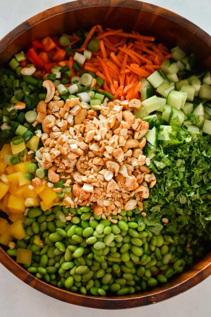 Adding cashews, cilantro and green onions to edamame salad.
