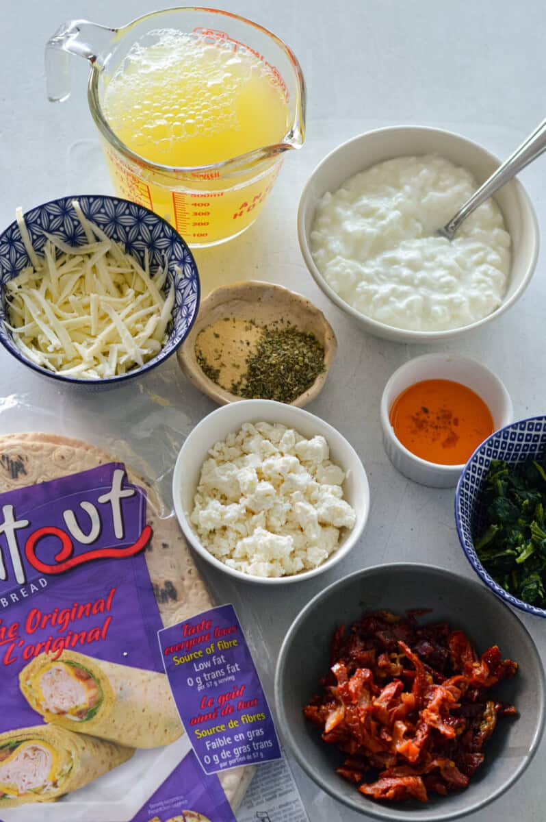 Ingredients including cottage cheese, whole wheat wrap, cheese, egg whties, spices, spinach and sundried tomato.