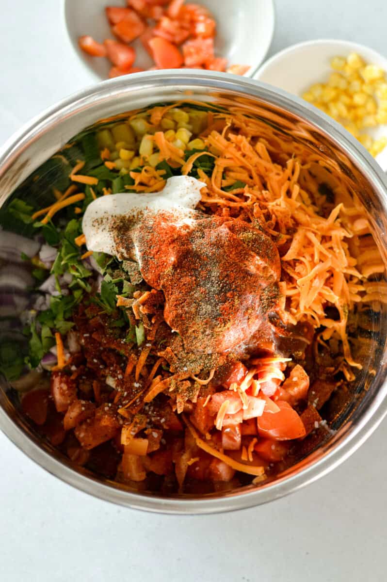 To a large mixing bowl, add diced chicken, black beans, corn, tomatoes, red onion, cilantro and cheese. Top with greek yogurt and bbq sauce and season with salt, black pepper, cumin, paprika and chili powder. Drizzle with lime juice if desired. 