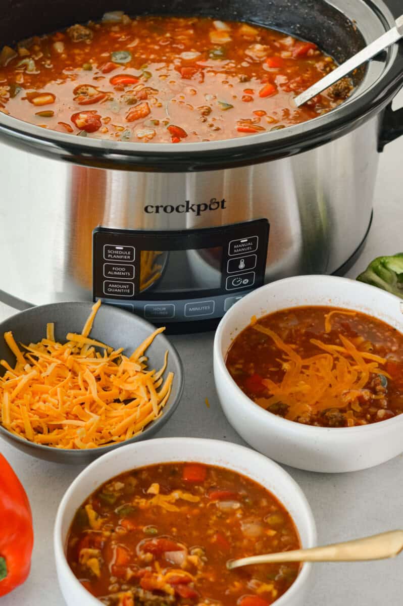 Serving two bowls of stuffed pepper soup from the slow cooker.