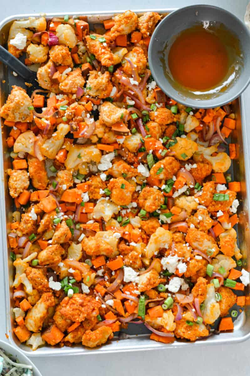 Birds eye of a sheet pan chicken and potatoes with buffalo sauce.