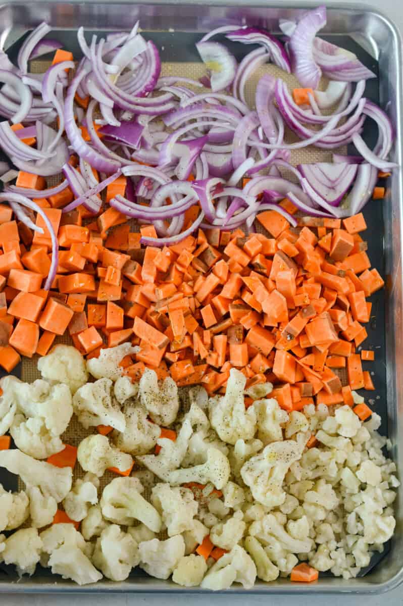 Sheet pan with red onion, sweet potato and cauliflower.