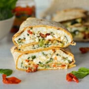 Two halves of a spinach feta egg white wrap stacked.