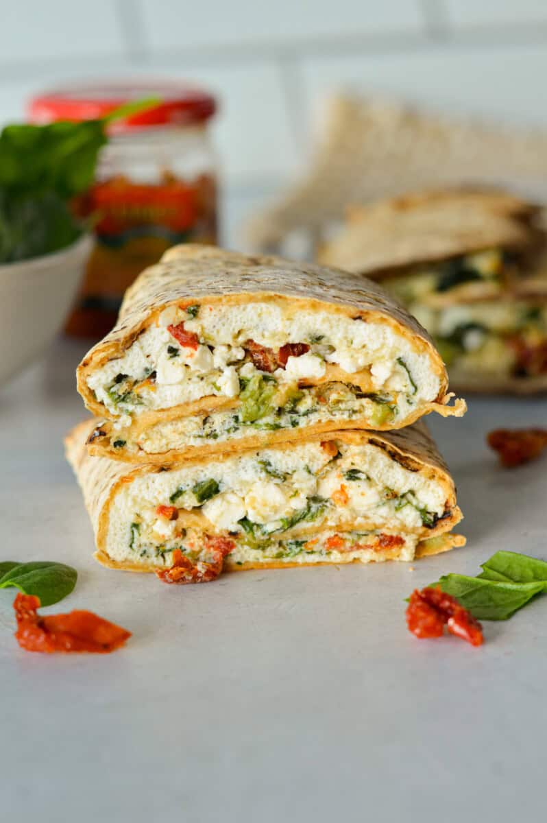 Two halves of a spinach feta egg white wrap stacked.