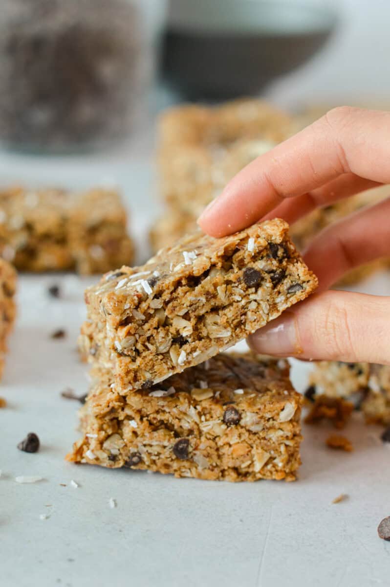 Picking up a gluten free granola bar off a stack.