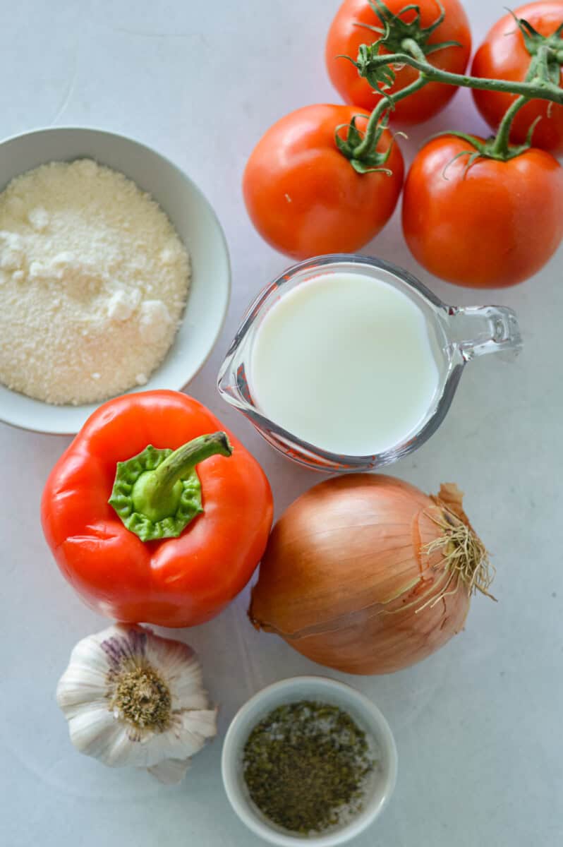 Ingredients including tomatoes, onions, parmesan, milk, garlic, onion and spices.