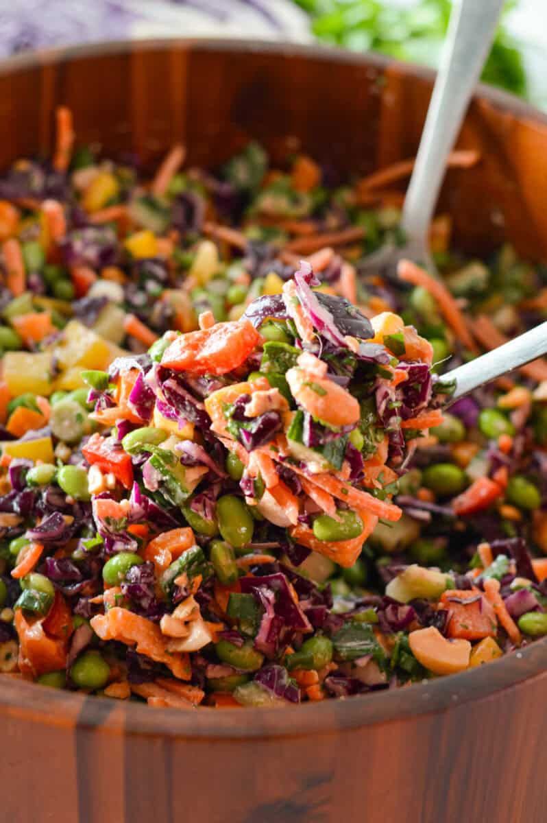 Miximg a rainbow edamame salad.