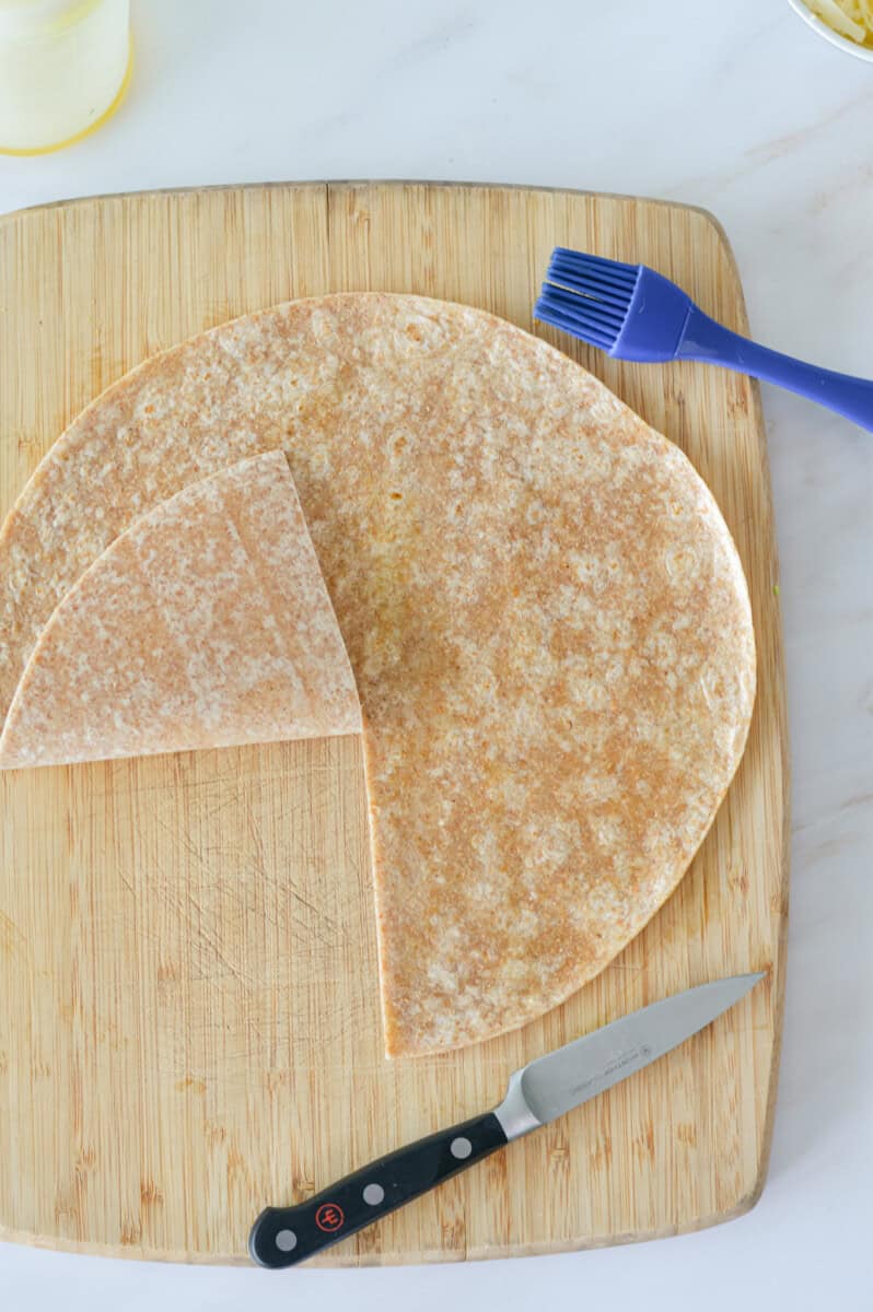 Slicing a tortilla and brushing with olive oil.