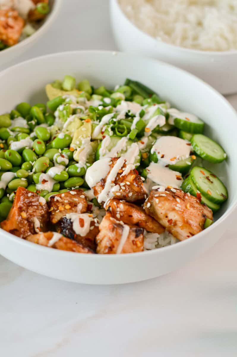 Salmon bowls with rice, veggies, sriracha mayo and edamame.
