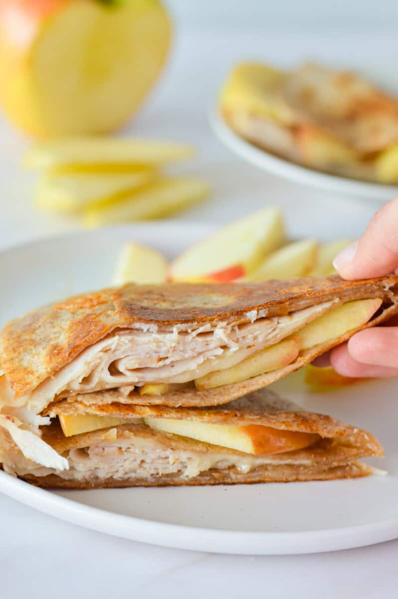 Picking up a piece of turkey apple cheddar quesadilla.