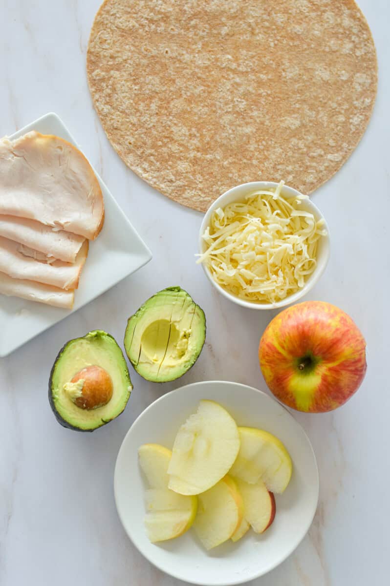 Ingredients including tortilla, turkey, cheddar, apple, and avocado.