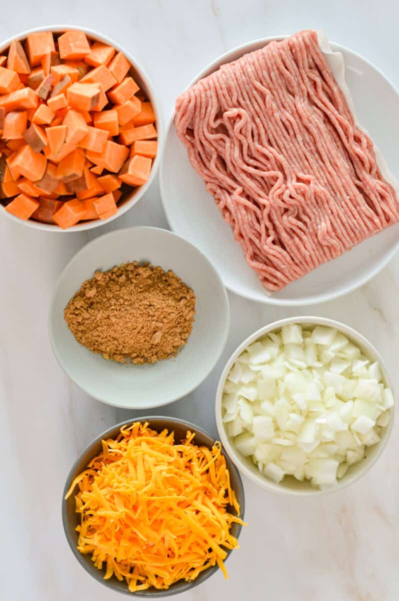 Ingredients including ground turkey, sweet potato, taco seasoning, onion and cheese.
