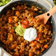 Birds eye of turkey sweet potato skillet topped with salsa, guacomole and sour cream.