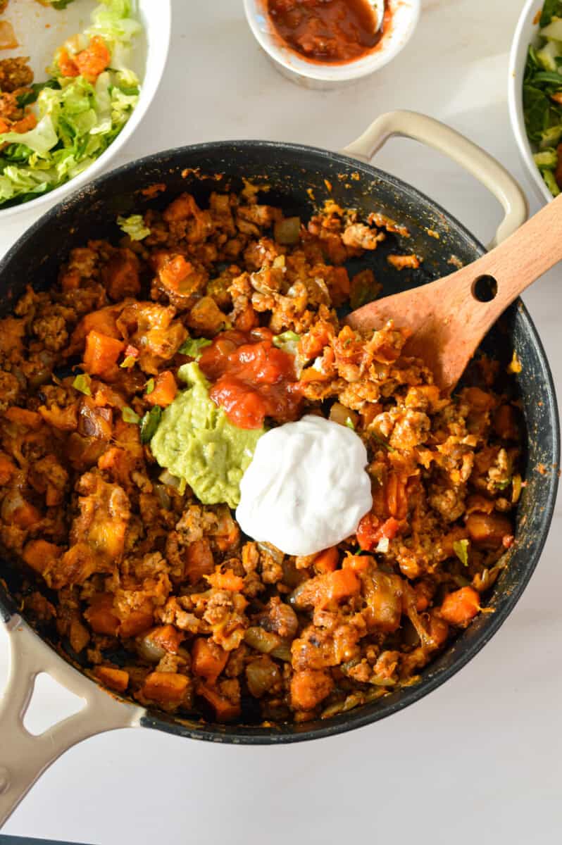 Birds eye of turkey sweet potato skillet topped with salsa, guacomole and sour cream.