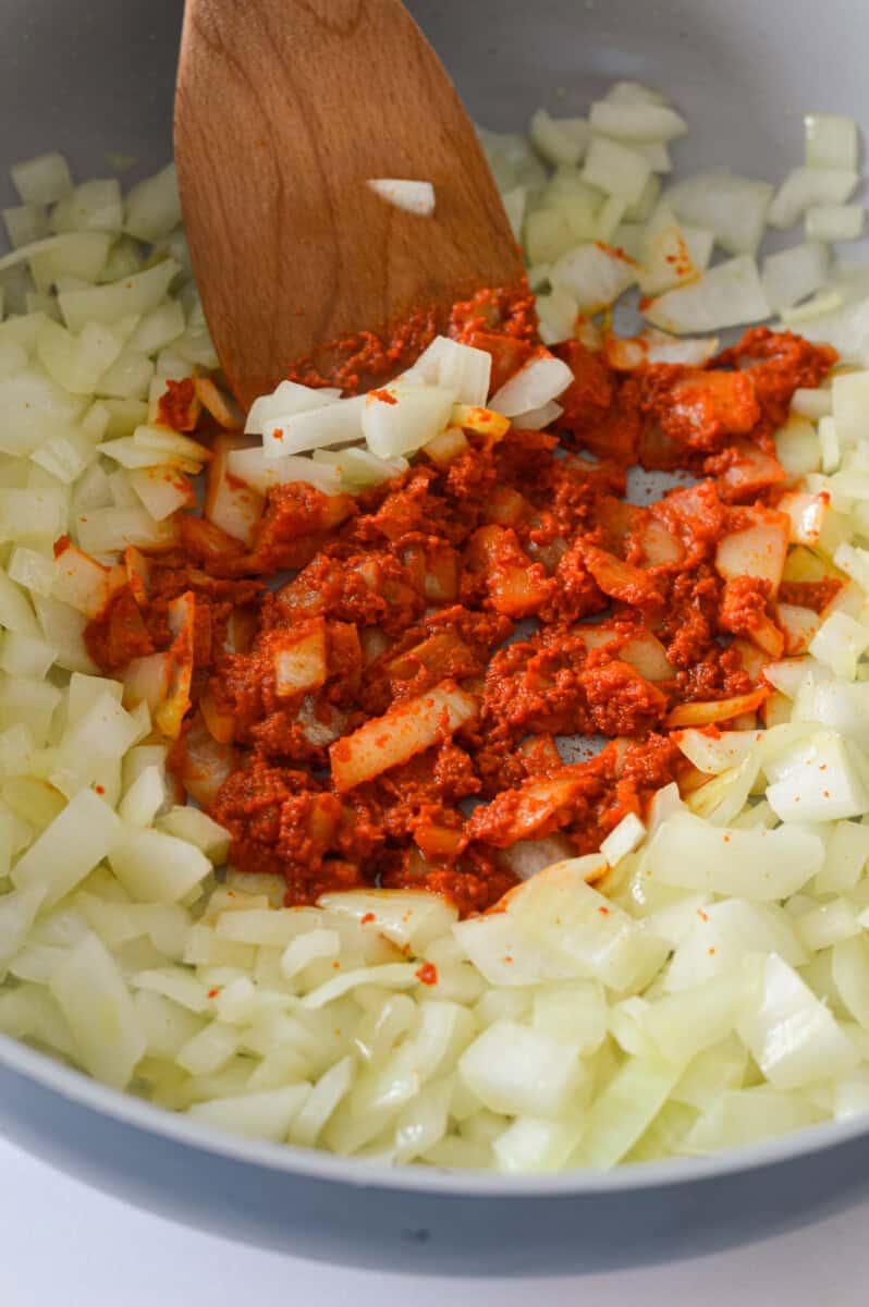 Adding red curry paste to onions.