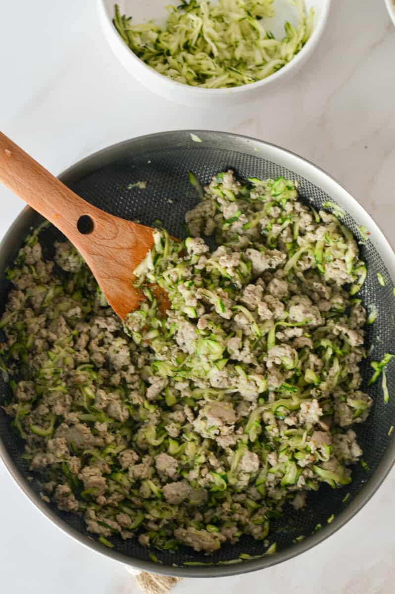 Cooking ground sausage with shredded zucchini.