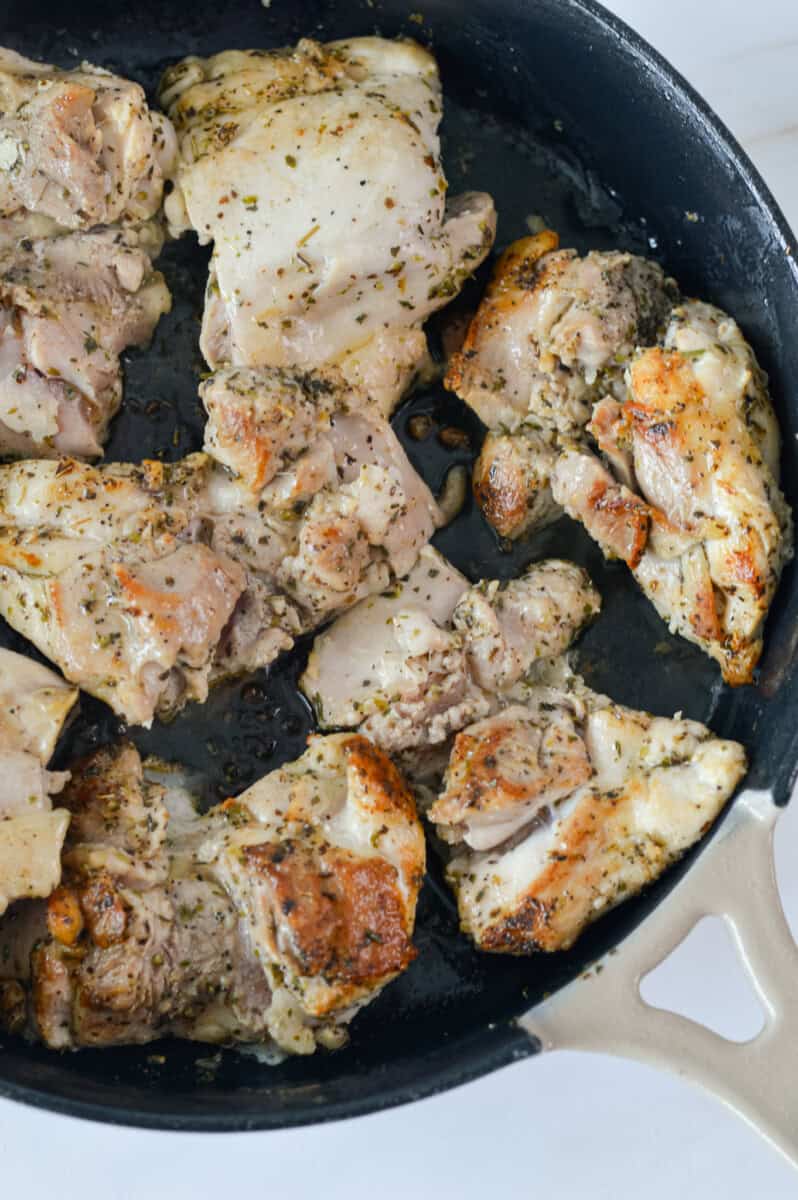 Cooking chicken thighs on a pan.
