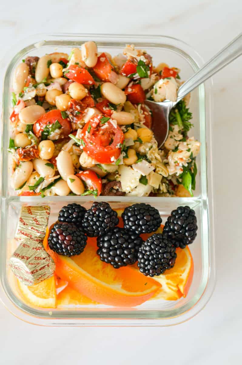 Adult lunchable with dense bean salad, chocolate and fruit.