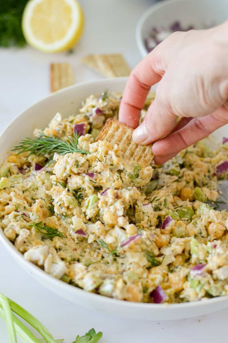 Dipping a cracker into chickpea tuna salad.