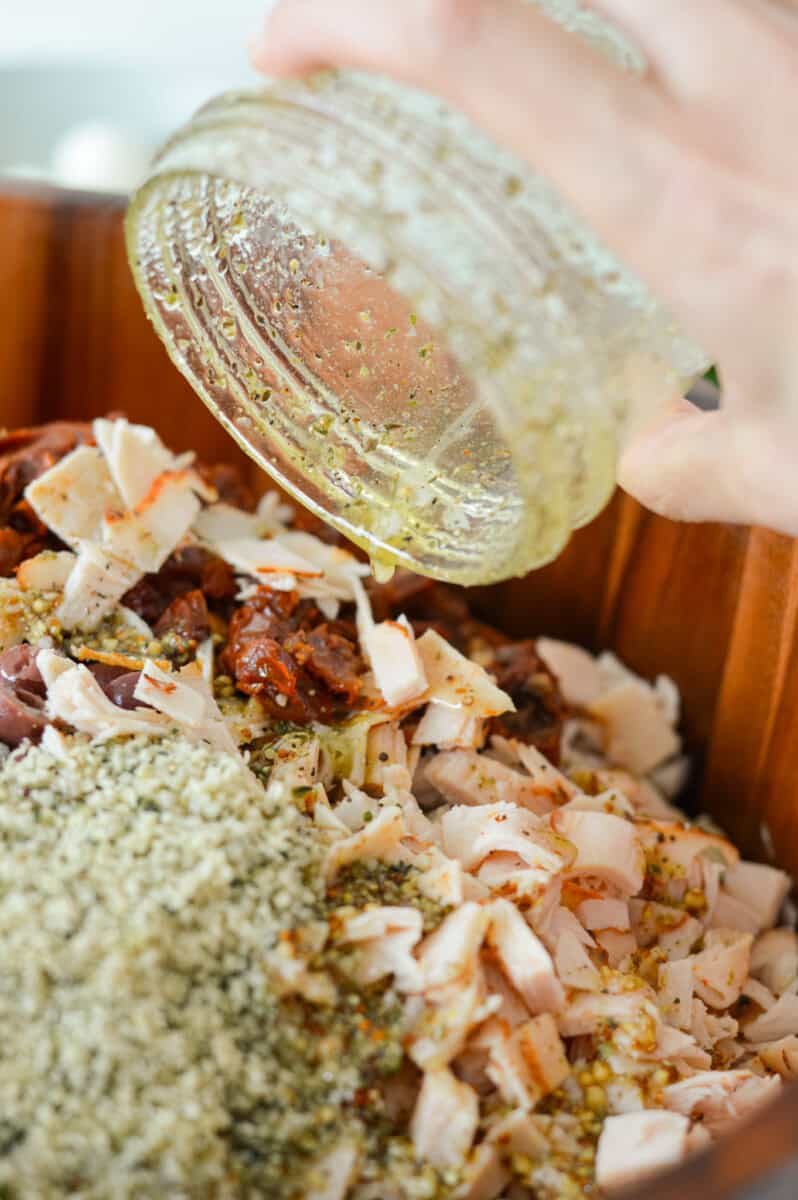 Pouring salad dressing on dense bean salad.