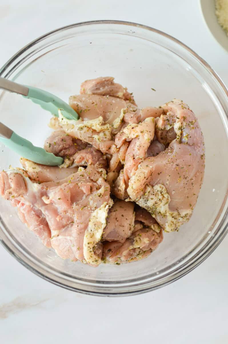 Marinating chicken thighs with spices.