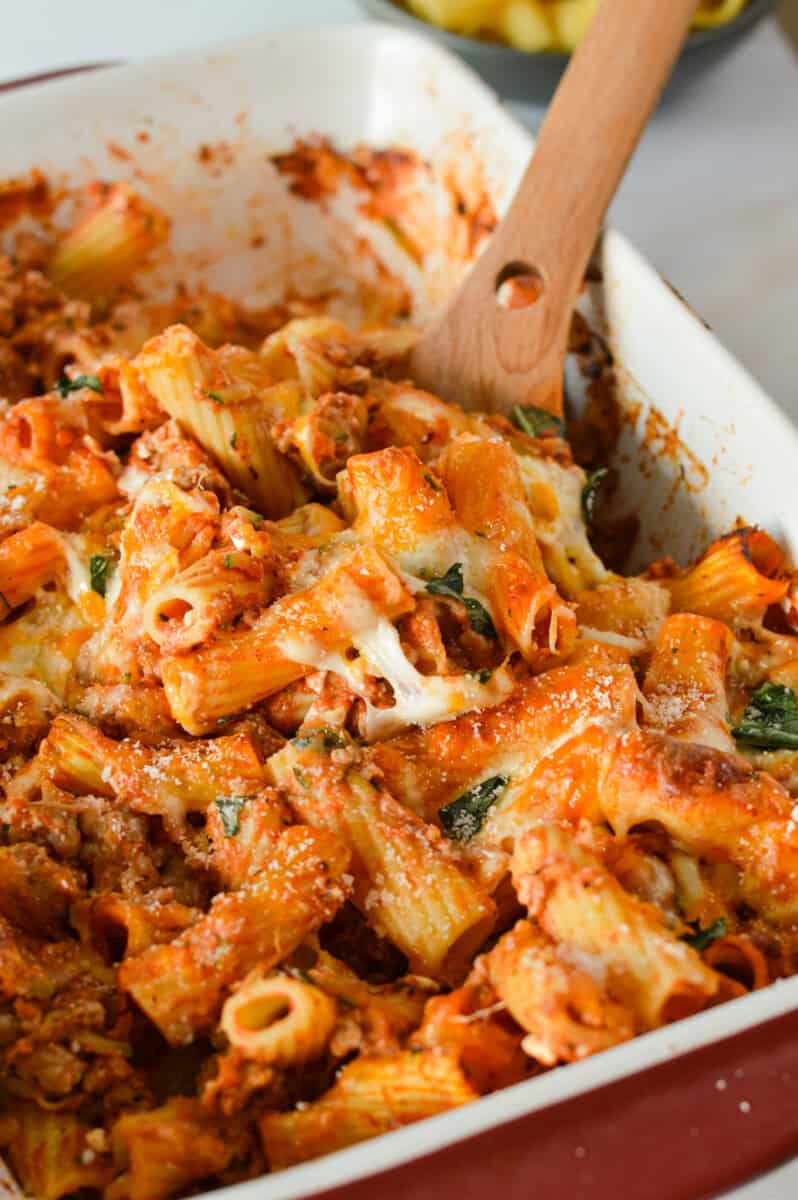 Scooping sausage pasta bake.