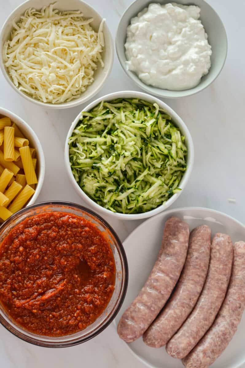 Ingredients including zucchini, sausage, pasta, tomato sauce, cheese, and cottage cheese.