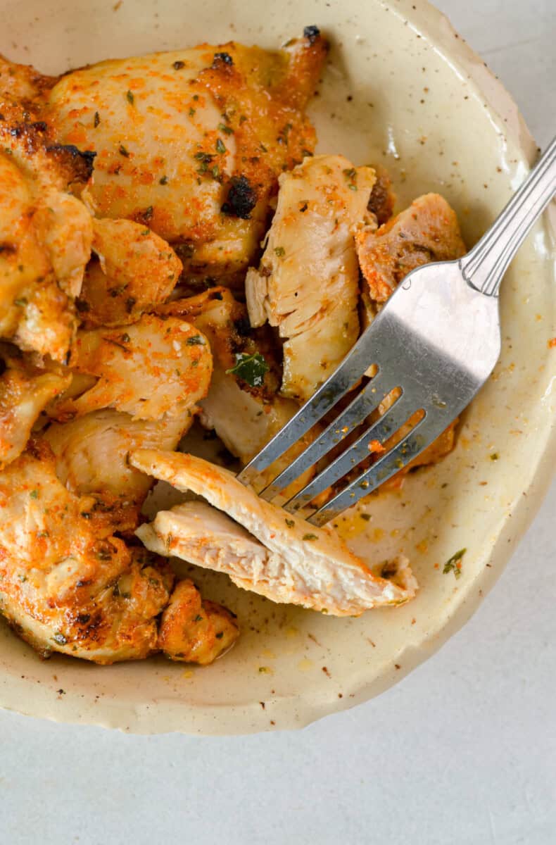 Birds eye with plate of air fryer chicken thighs.