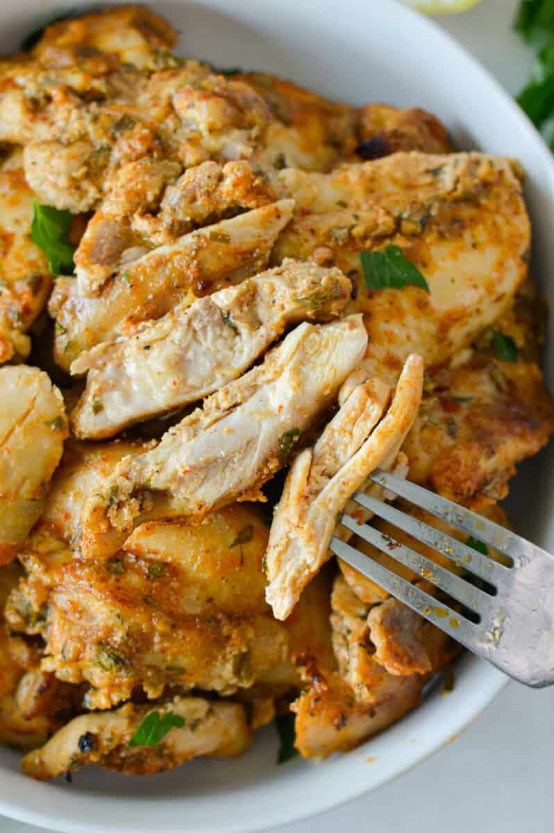 Bowl of sliced greek chicken thighs.
