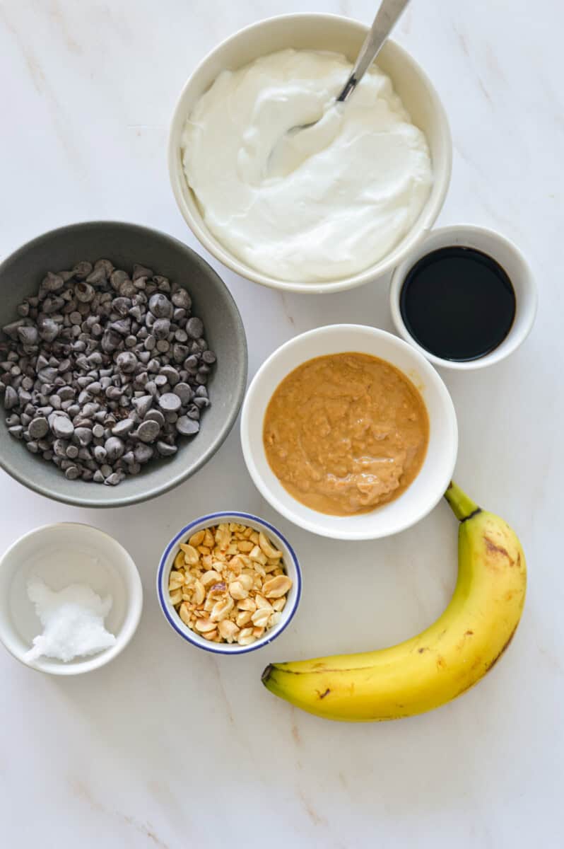 Ingredients including banana, greek yogurt, peanut butter, coconut oil and chocolate chips.