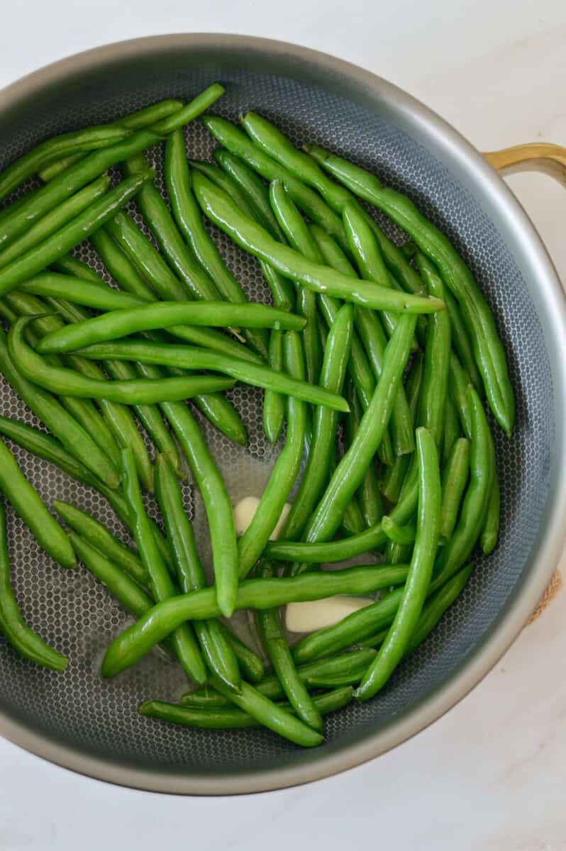 Cooking green beans in butter.