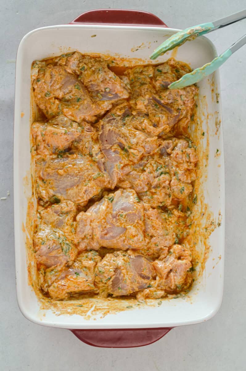 Tray with marinated greek yogurt chicken thighs.