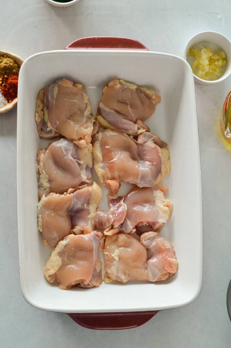 Tray with raw chicken thighs.