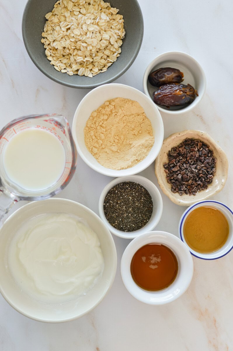 Ingredients including oats, caramel, chia seeds, protein powder, medjool dates, greek yogurt, milk and cacao nibs.