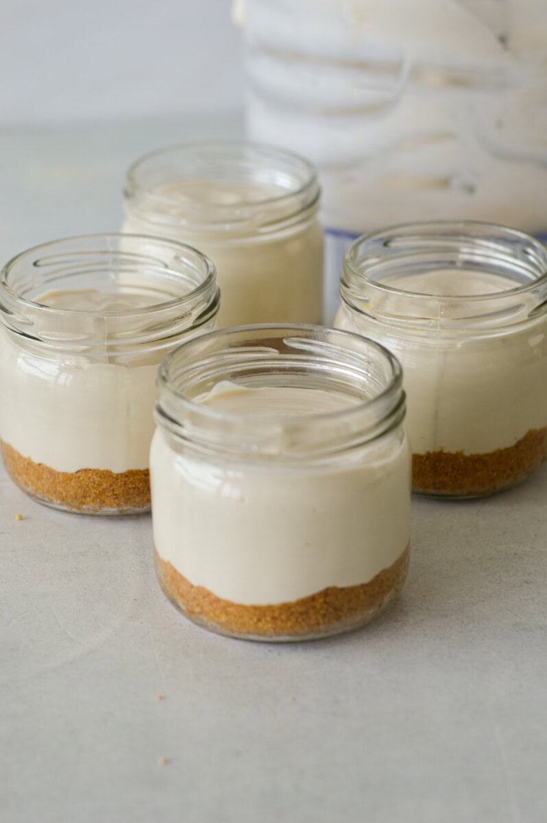 Adding cheesecake filling layer to cheesecake jars.
