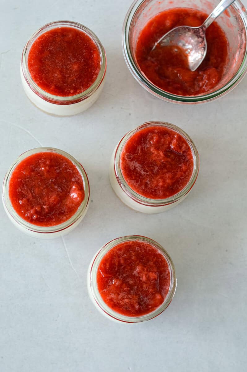 Adding strawberry compote to protein cheesecake jars.