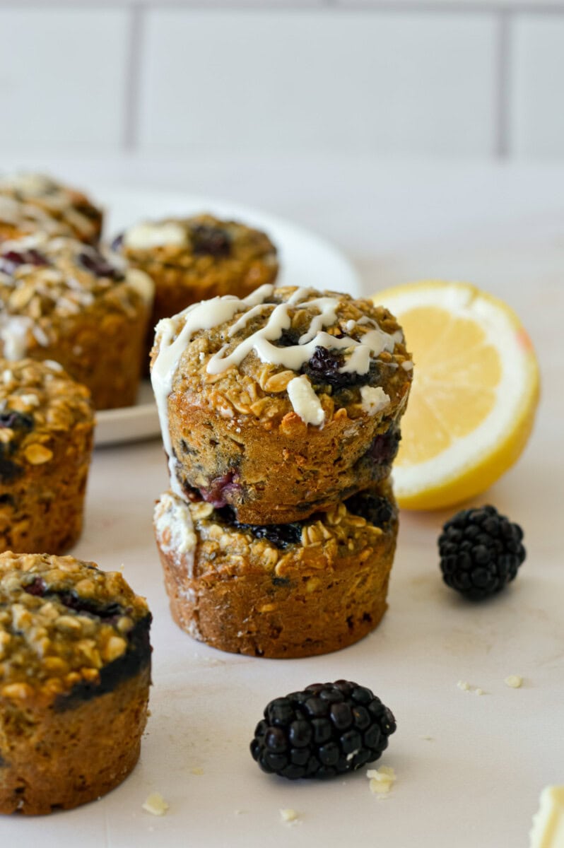 Two stacked lemon and blackberry oat cups with drizzle on top.