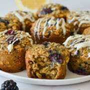Plate of lemon and blackberry oatmeal cups with icing drizzle.