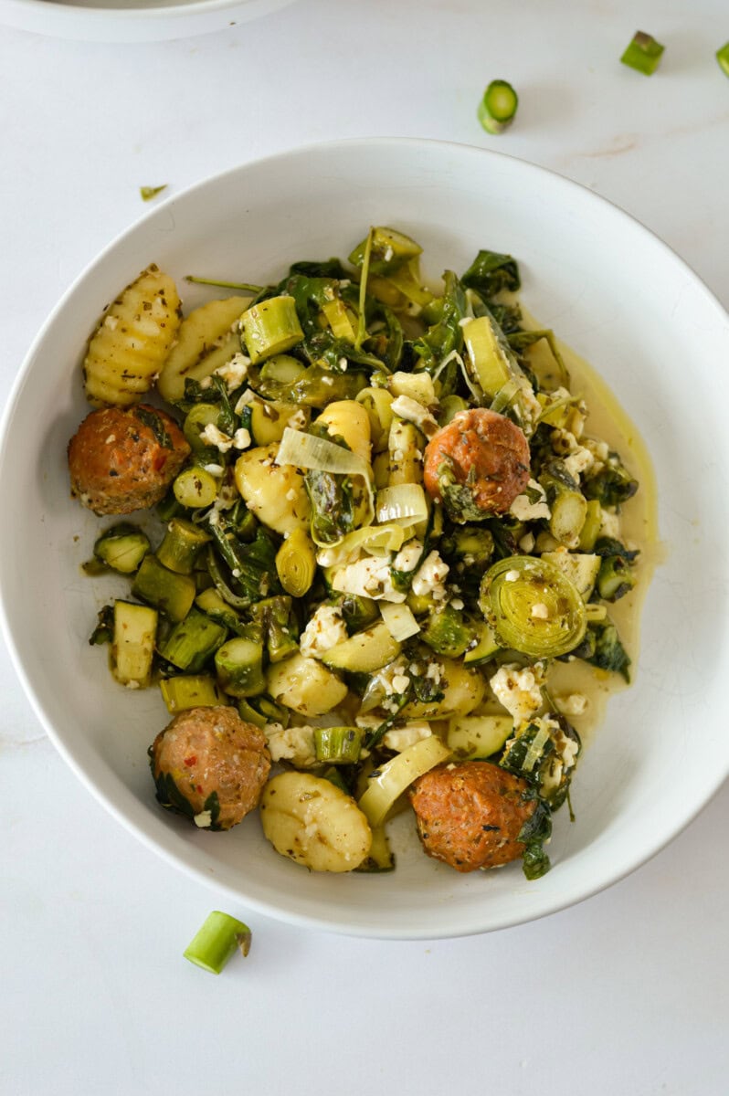 Birds eye of a bowl with gnocchi, asparagus and sausage.