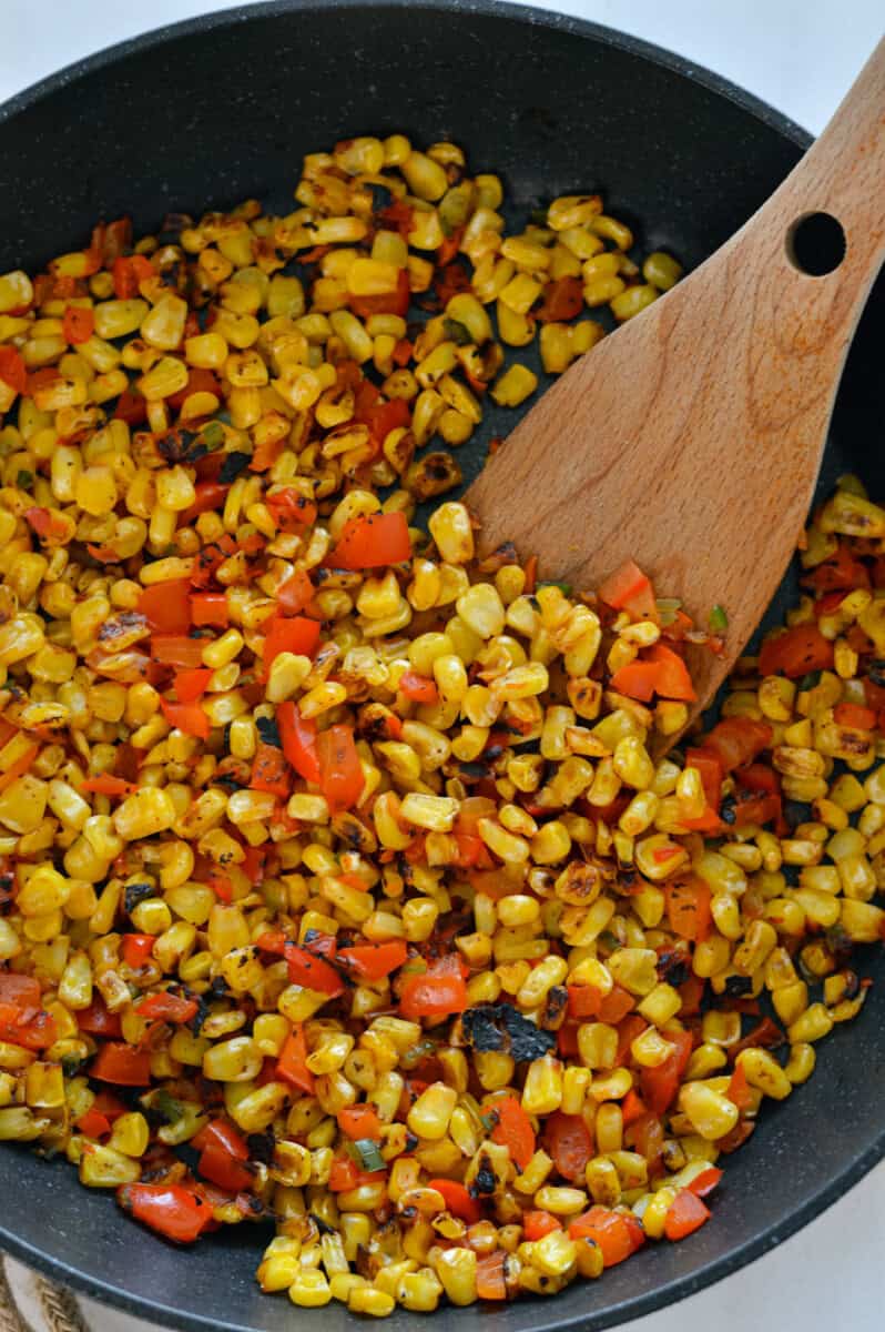 Cooking Mexican street corn on a pan.
