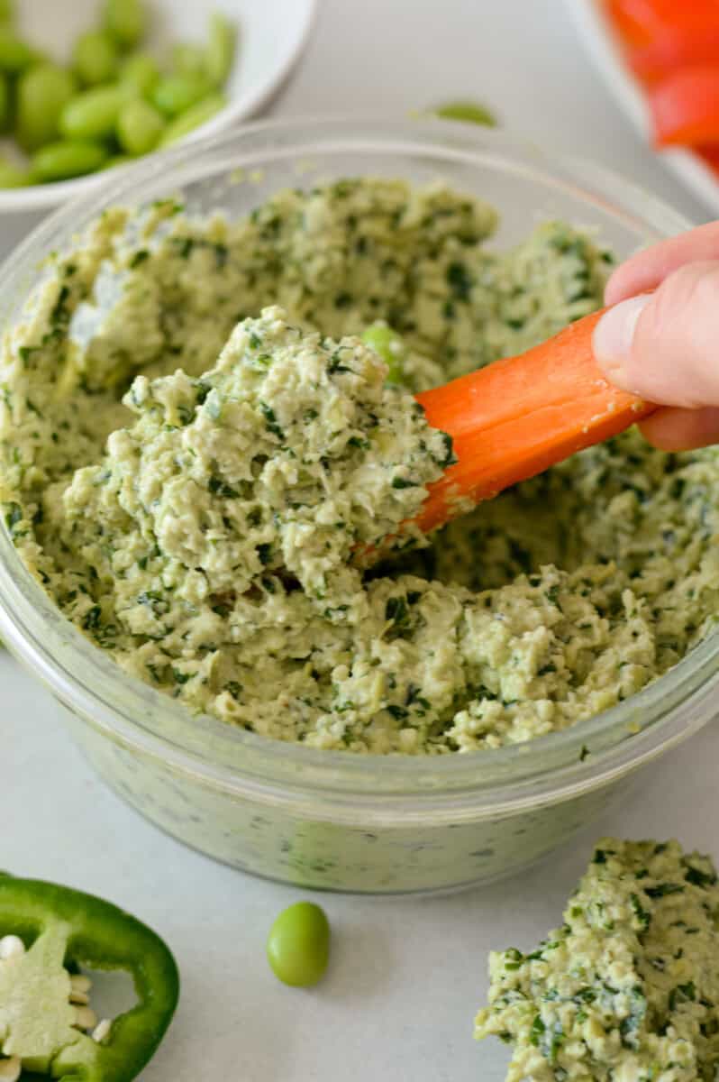 Dipping a carrot in edamame dip.