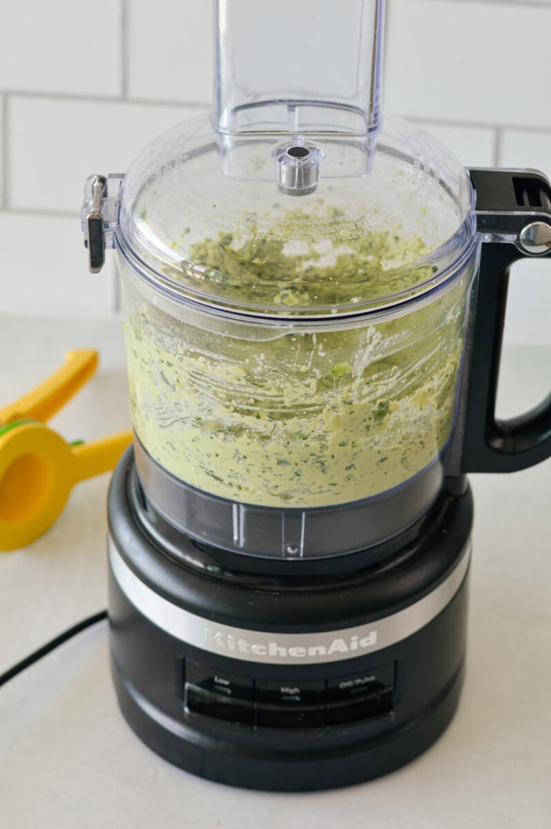 Blending kale edamame dip in a food processor.