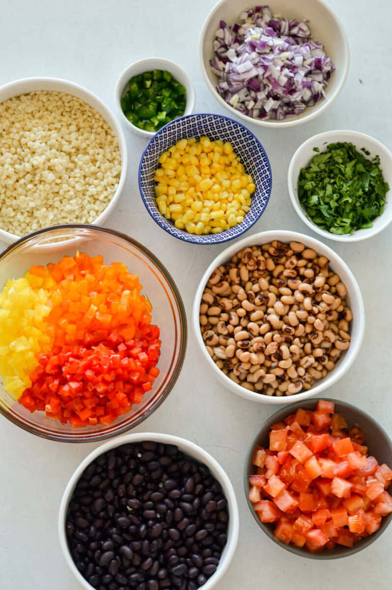 Ingredients including pearl couscous, bell pepper, cilantro, black eye peas, corn, tomato, red onion and jalapeno,